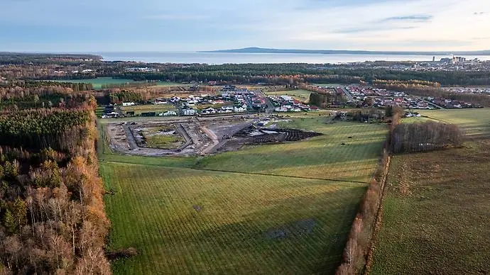 Drönarvy över en grönområden och en stad.
